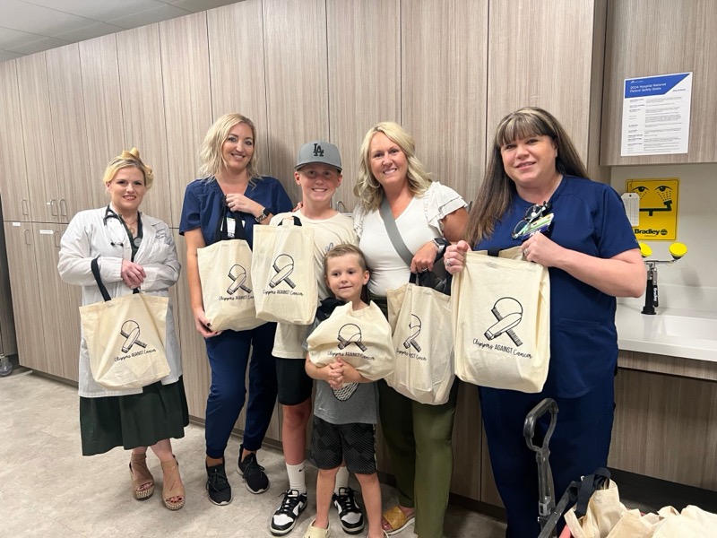 The Clippers Against Cancer team with hospital staff holding care bags