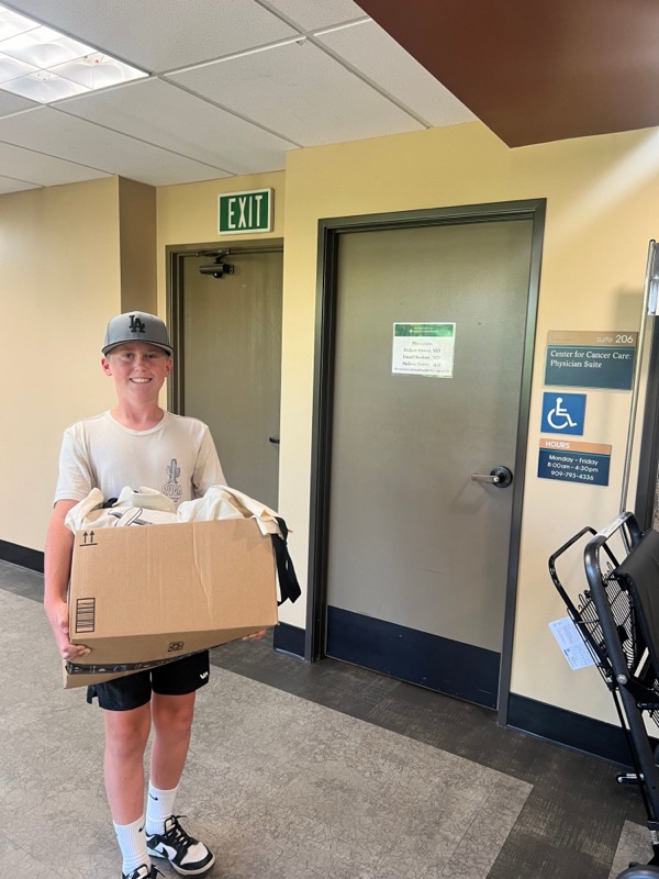 A young volunteer carrying a box of care baskets at the Center for Cancer Care